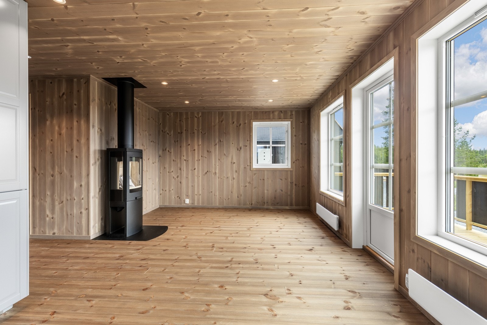 Store vinduer som strekker seg fra gulv til tak slipper inn rikelig med naturlig lys, noe som skaper en lys og luftig atmosfære gjennom hele dagen. Galleribilde