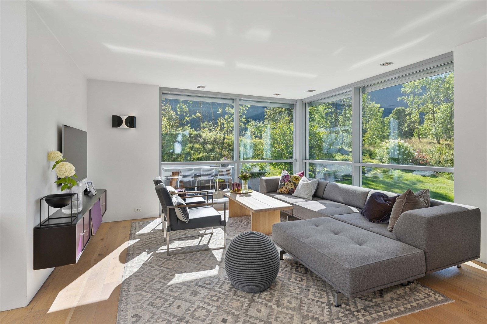 Kjøkken og stue har en nydelig åpen løsning med god spiseplass, romslig innredning, peisinnsats og halvplan til hagestuen som er innglasset og har utgang til hagen. Galleribilde