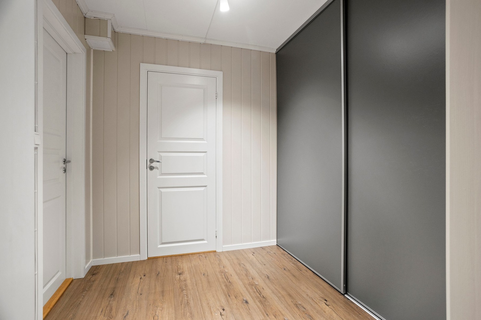 Gang i sokkeletasje med inngang til ett soverom og videre gang. Innredet med skyvedørsgarderobe. Galleribilde