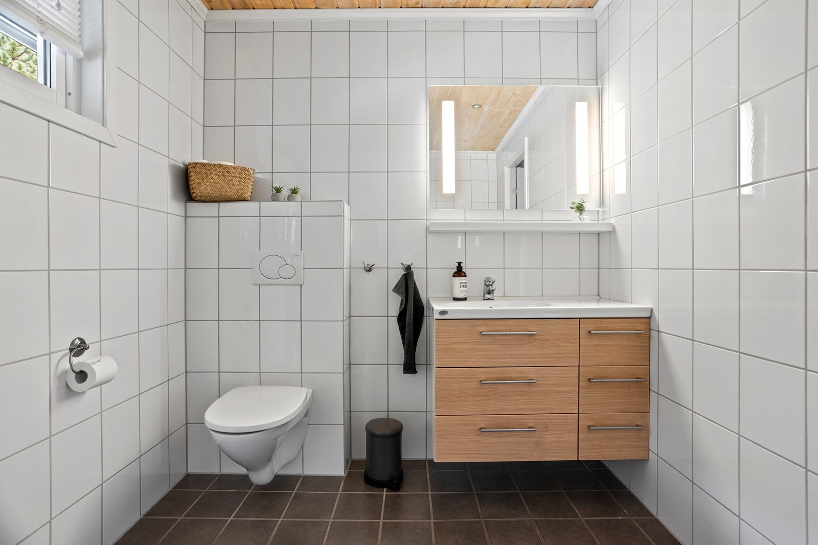 Badet er utstyrt med bl.a. toalett, servant og speilskap samt dusjsone. Galleribilde