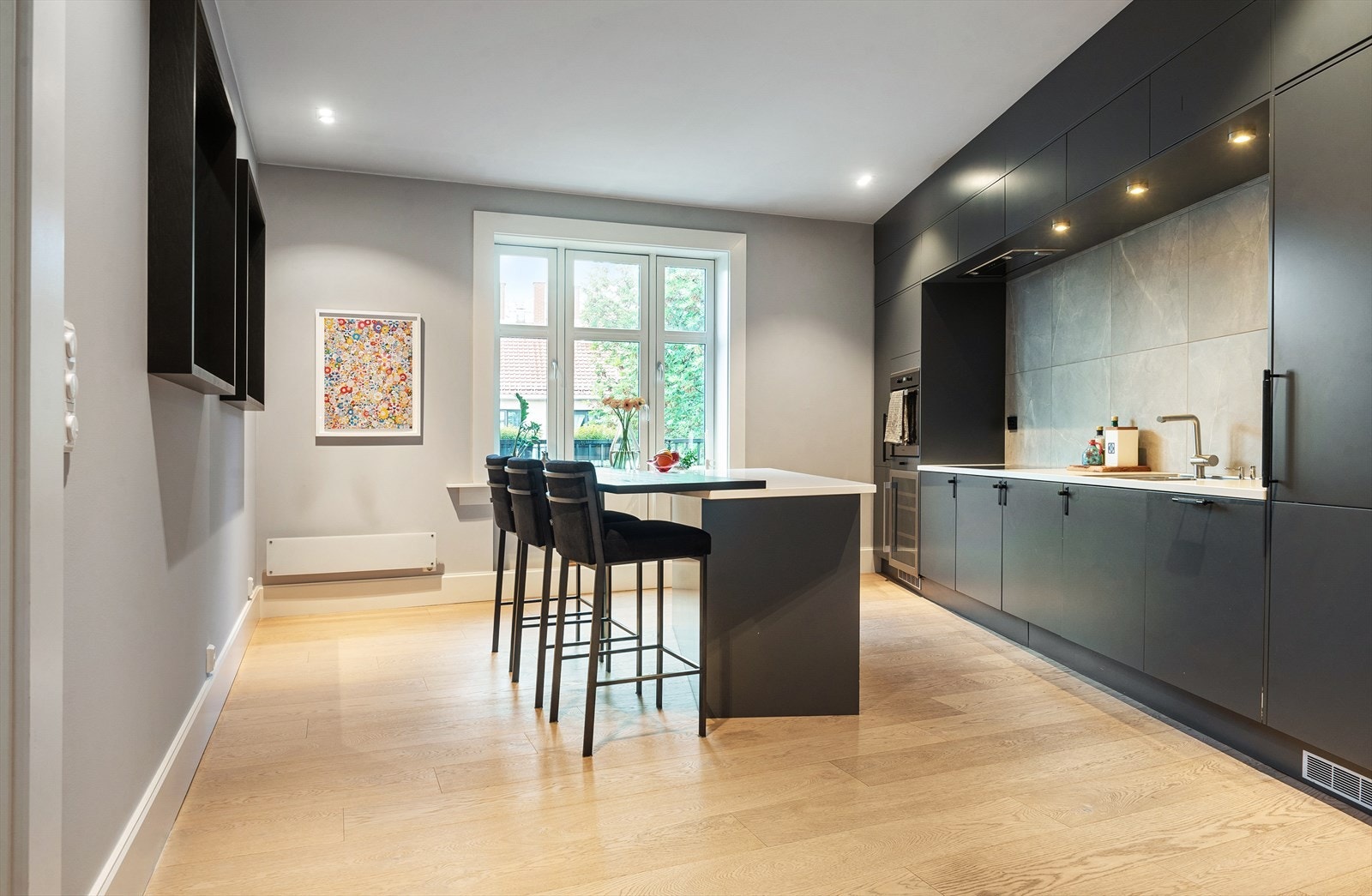 Velutstyrt Sigdal kjøkken fra 2015 med matte og glatte fronter, kompositt benkeplate og flis på vegg over benk. Galleribilde