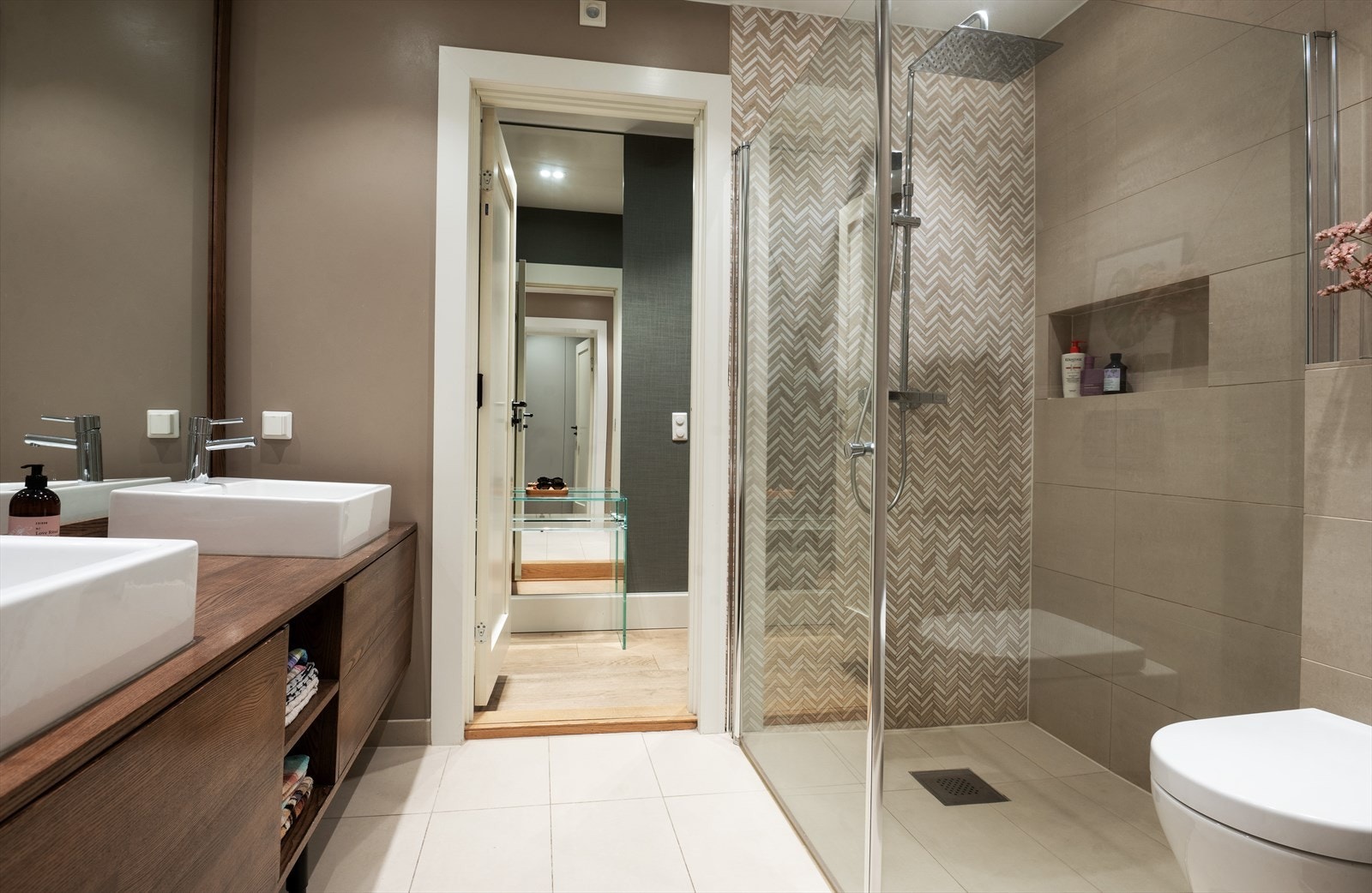 Flislagt gulv med varmekabler, flislagte vegger og malt himling med downlights. Galleribilde