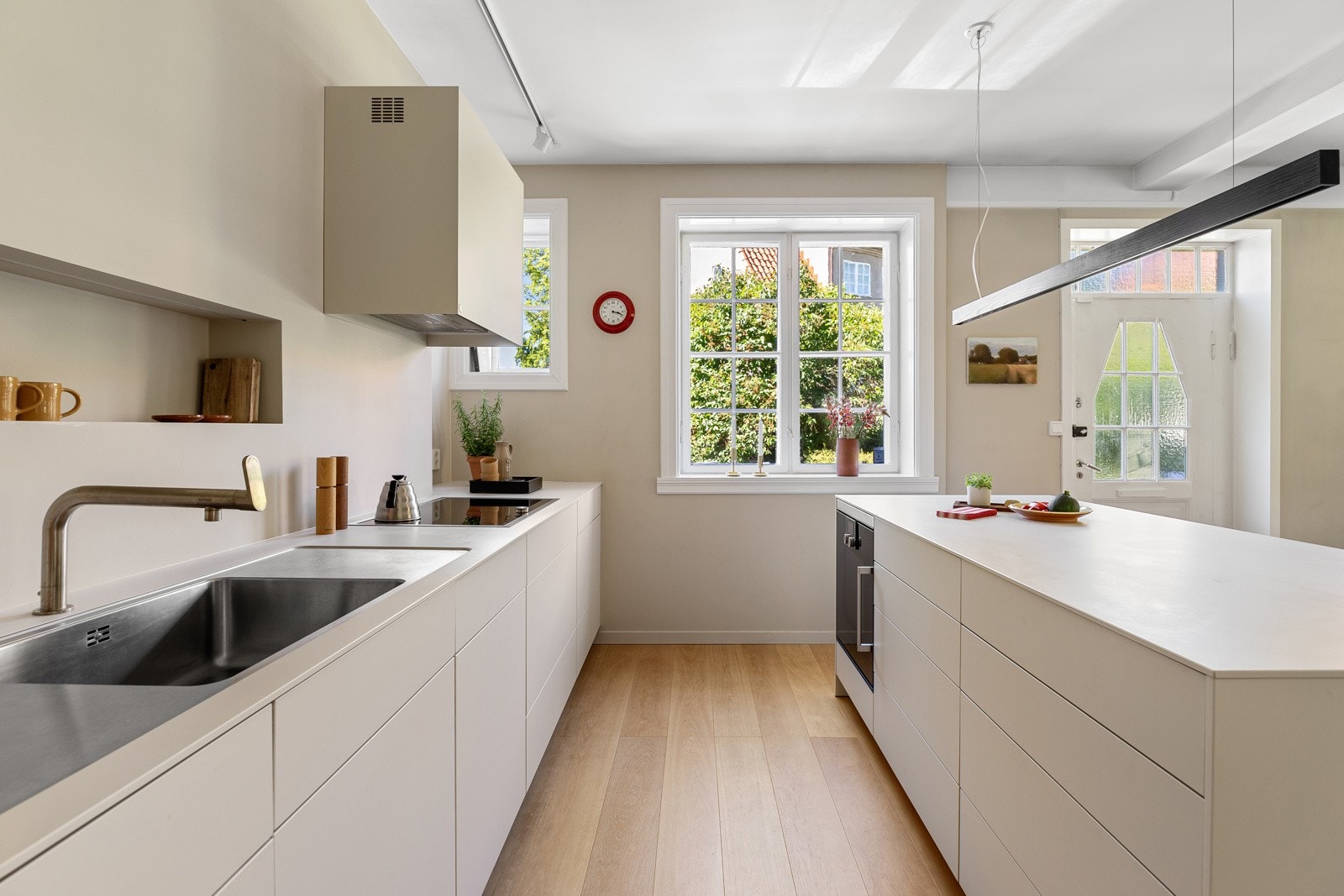 Premium kjøkken fra Bulthaup i fargen Kaolin med glatte fronter og benkeplate i laminat, spesialtilpasset med høy kvalitet Galleribilde