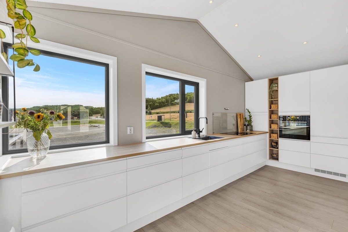 Kjøkkenet har en moderne og nordisk stil, hvor man har valgt å ikke ha overskap. Dette gir en luftig følelse og skaper et helhetlig inntrykk. Galleribilde