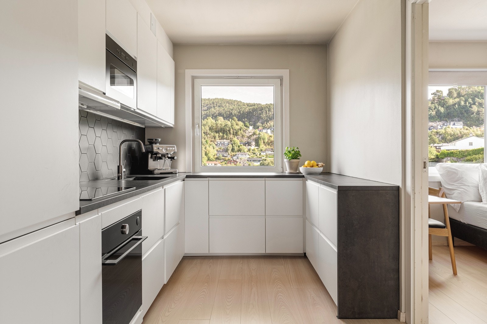 Innredningen består av slette hvite fronter og en slitesterk laminat benkeplate med underlimt vask av kompositt. Galleribilde