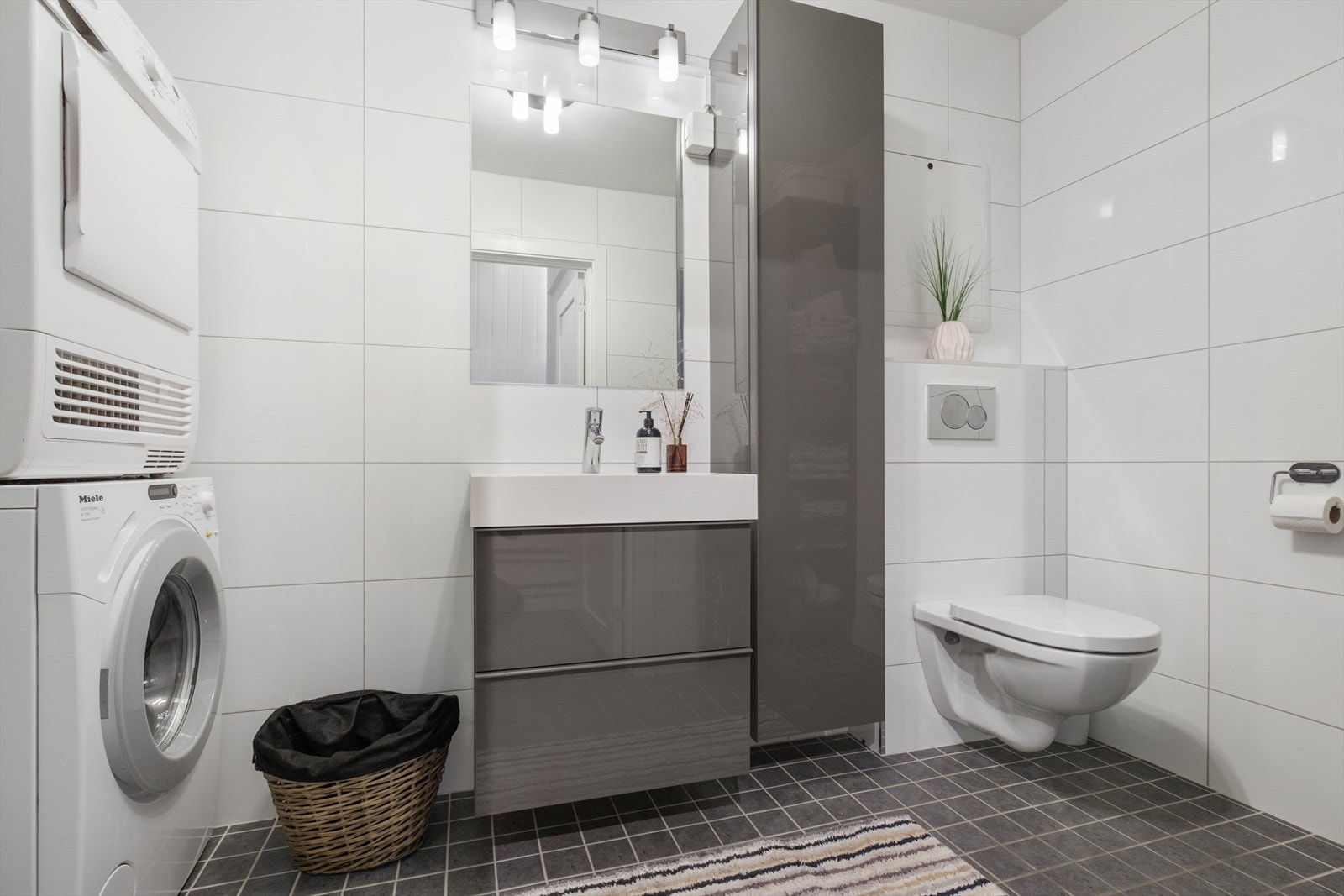 Badet er utstyrt med varme i gulv, innredning m/servant, vegghengt wc, dusjhjørne samt opplegg for vaskemaskin Galleribilde