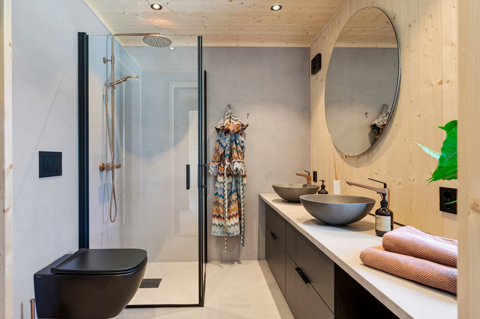 Badet har praktisk skap med doble servanter, dusj med foldbare dører og vegghengt toalett. Galleribilde