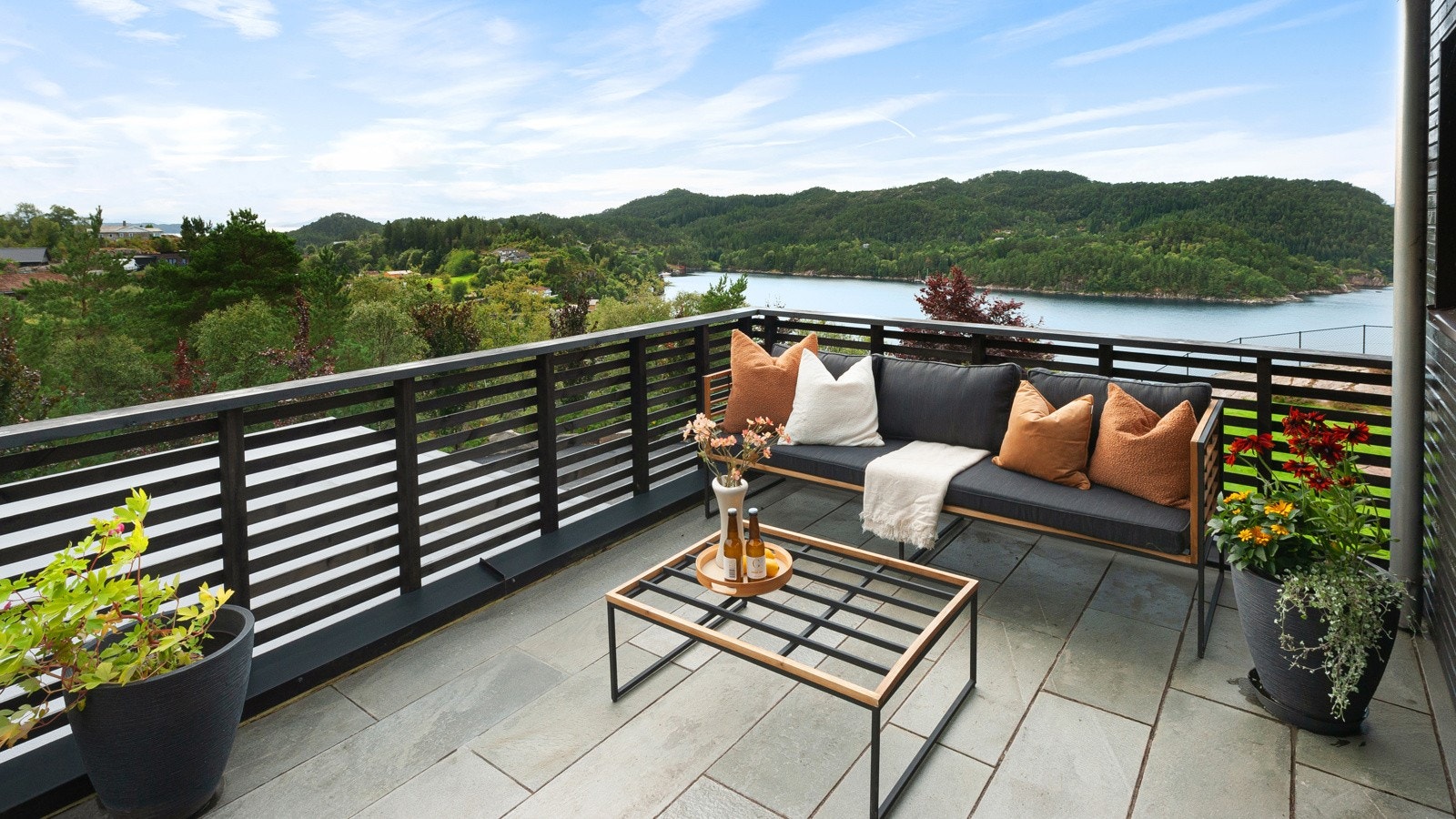 Sydvendt terrasse med utgang fra hjemmekontor/soverom. Her sitter man uforstyrret og kan nyte både roen og den herlige utsikten. Galleribilde