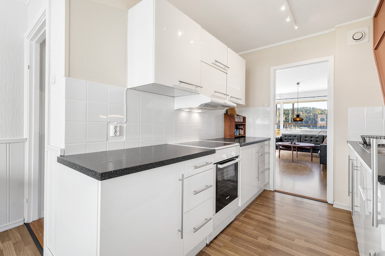 Innredningen har frittstående kjøl/fryseskap, oppvaskmaskin og komfyr Galleribilde