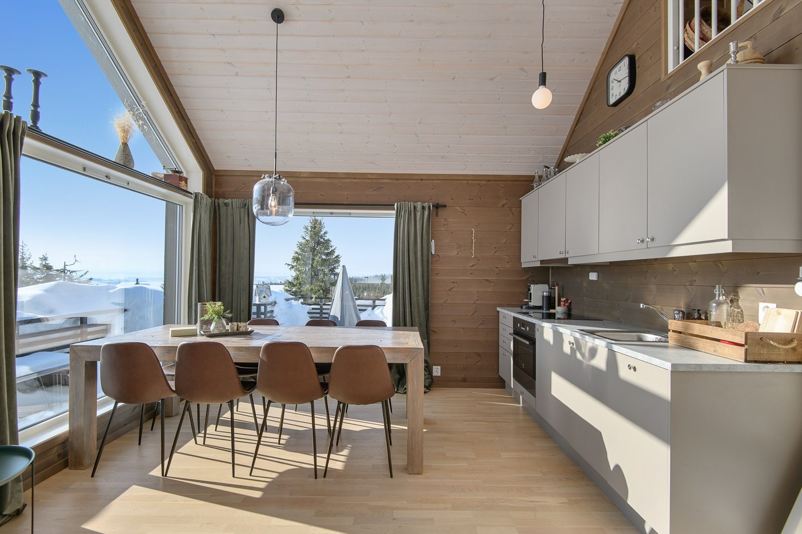 Kjøkkenet har innredning med glatte fronter, i en lun og delikat fargetone. Integrerte hvitevarer. Galleribilde