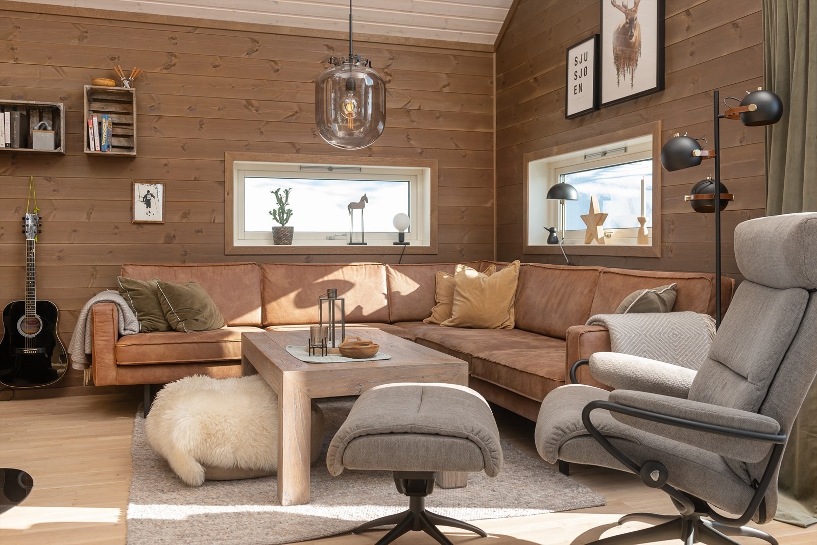 To vinduer over sofaen gir fint lys inn i rommet. Galleribilde