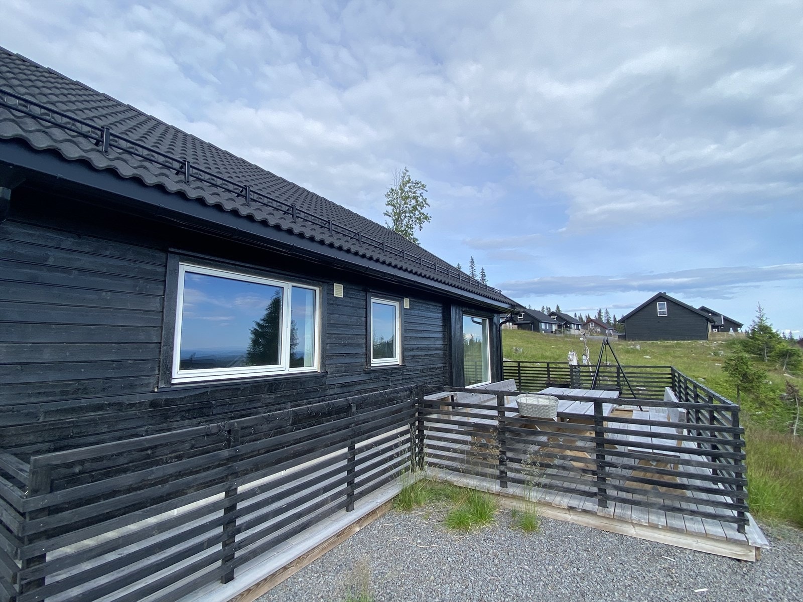 Romslig terrasse utenfor stua der en kan slappe av i solveggen. Galleribilde