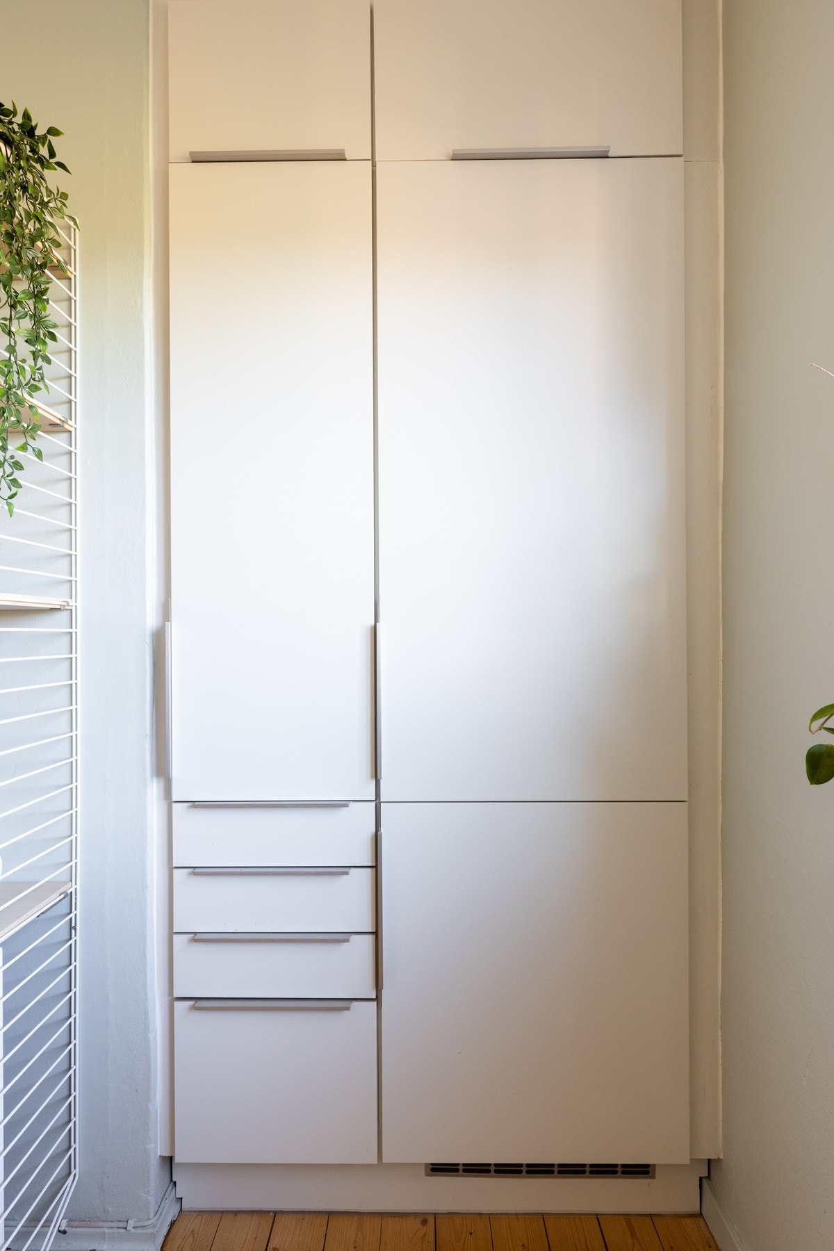 I en pen nisje er det høyskap og integrert kjøleskap med fryser Galleribilde