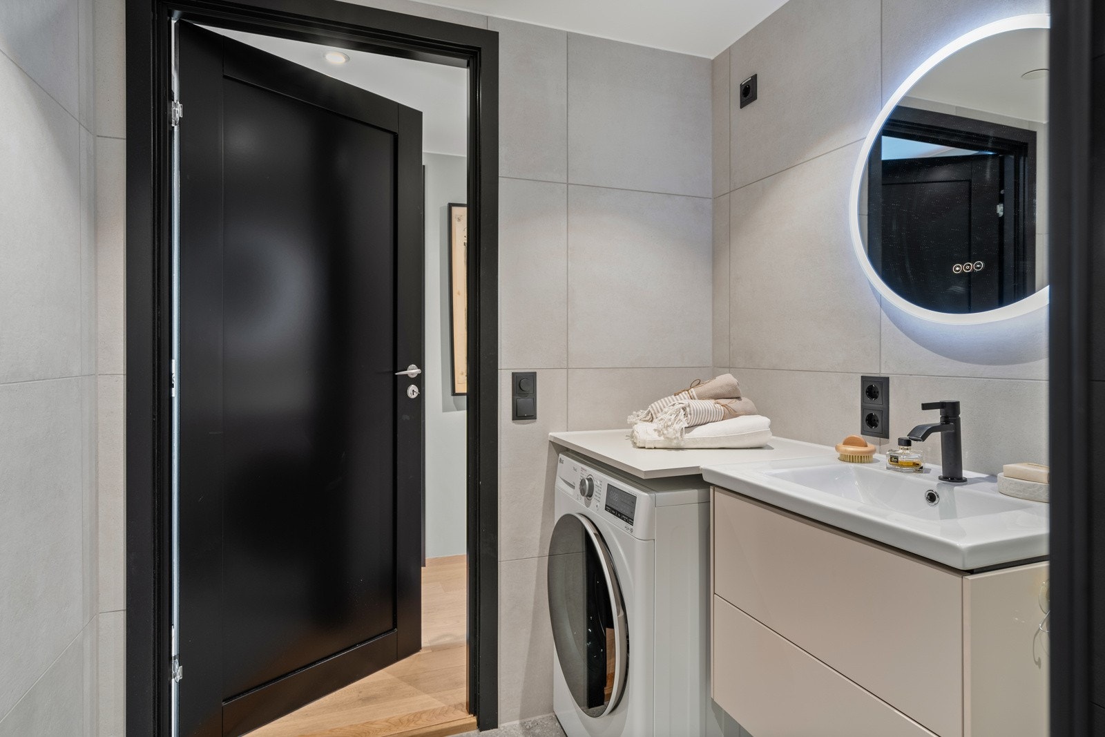 Speil med LED-lys. Det er opplegg for vaskemaskin og tørketrommel. Galleribilde