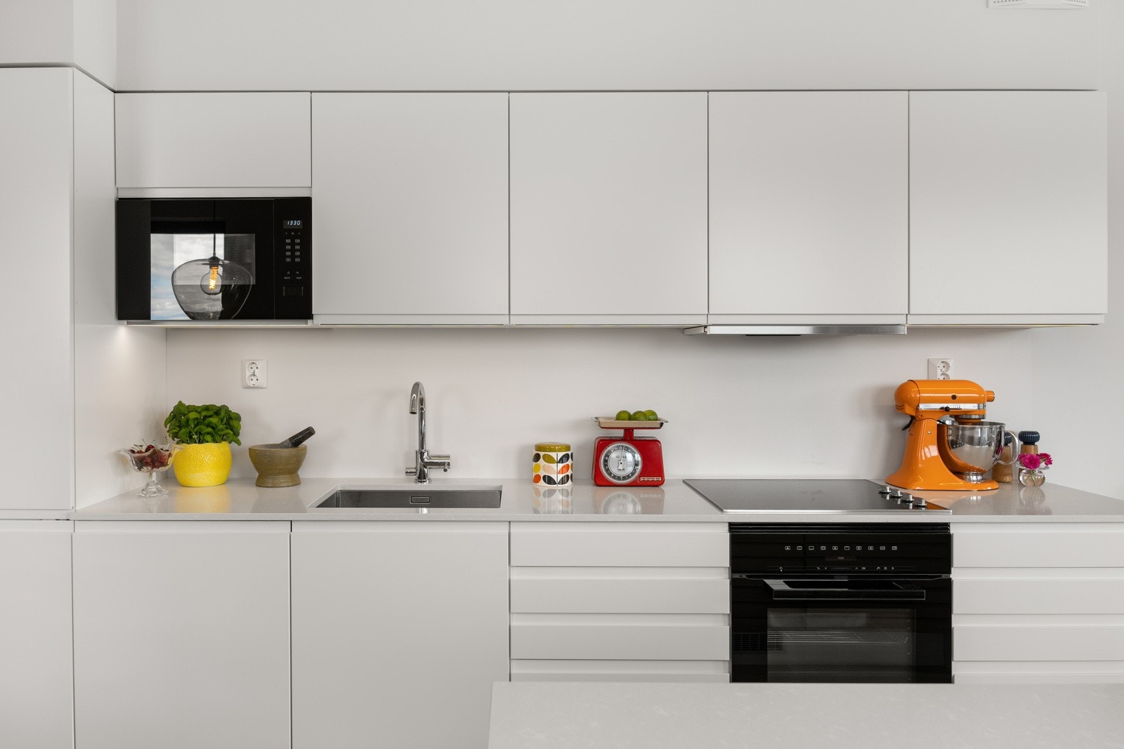 HTH kjøkkeninnredning med glatte fronter og kvartskompositt benkeplater. Galleribilde