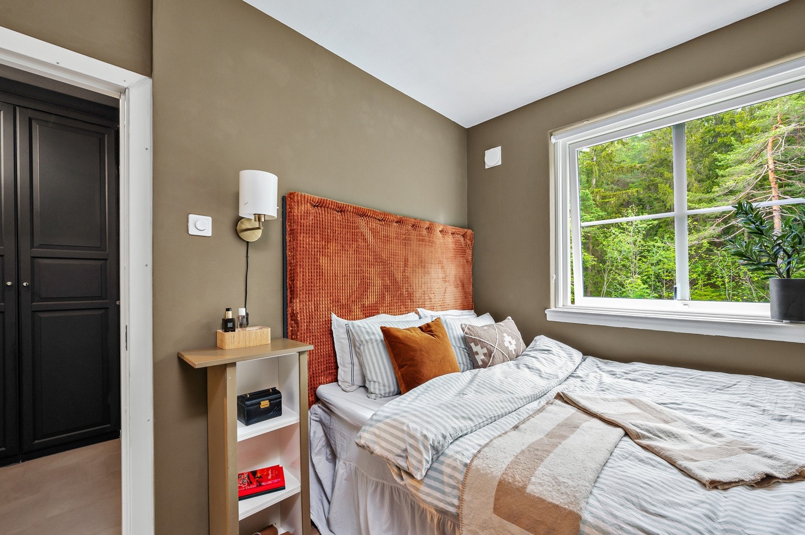 Lyst og innbydende soverom med plassbygget seng og plass til nattbord. Galleribilde