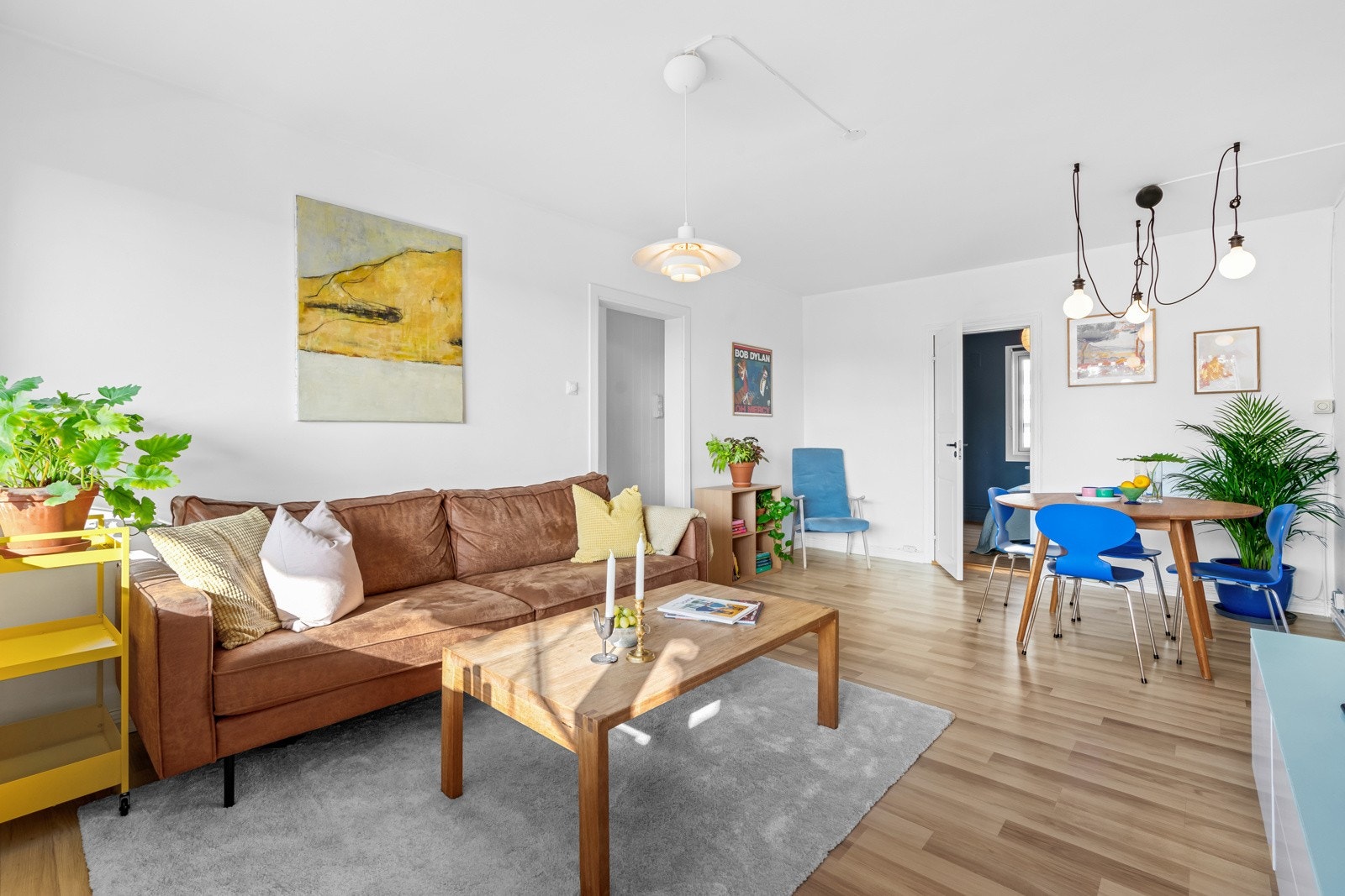 Leiligheten har en pen stue med laminatgulv, og malte, glatte veggflater Galleribilde