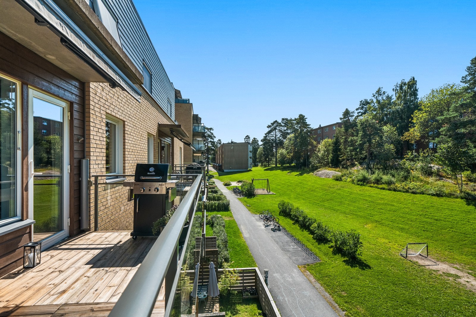 Balkongen har dekke i tre og på husveggen er det montert utebelysning, terrassevarmer og utestikk Galleribilde