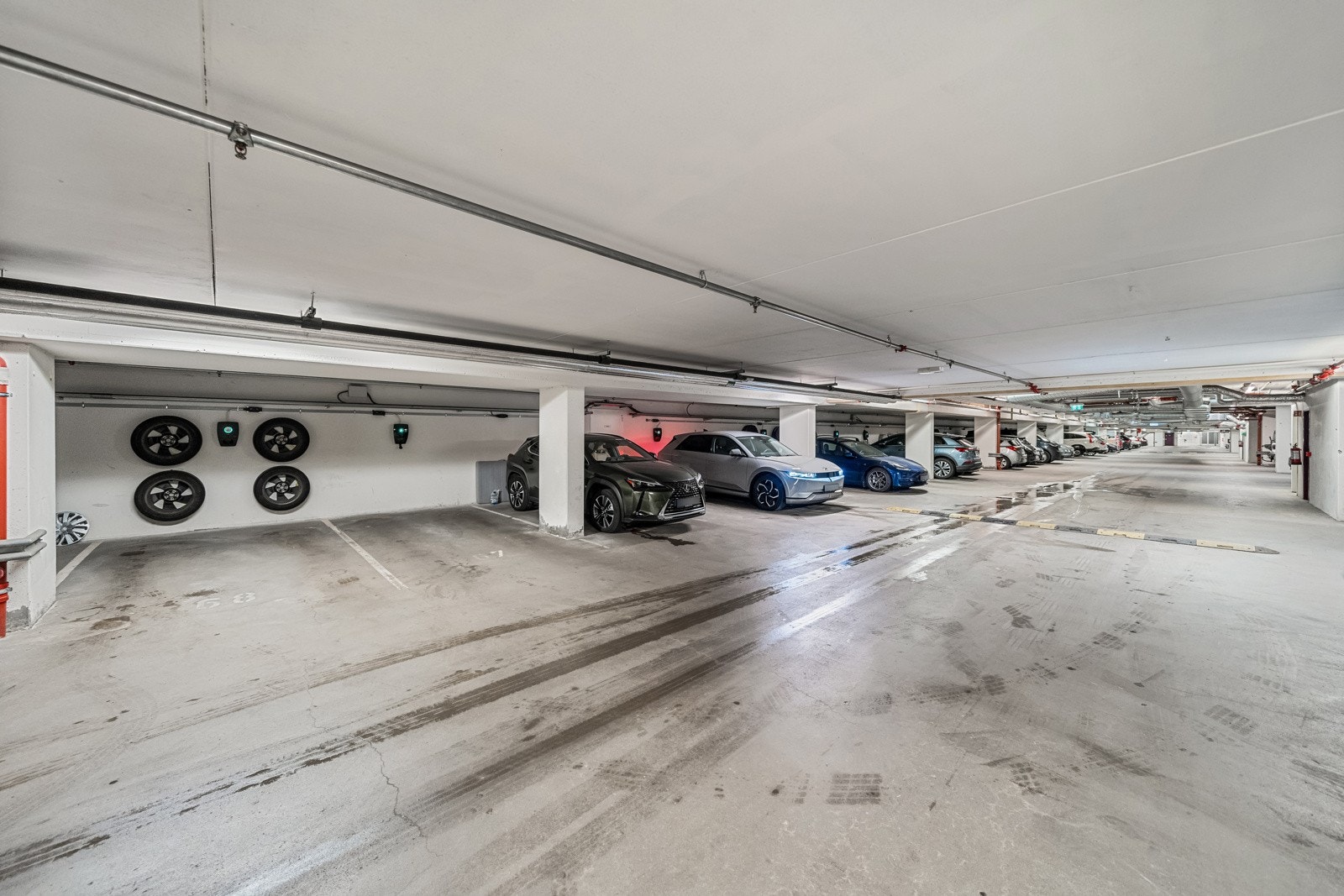 Det medfølger biloppstillingsplass i felles, lukket garasjeanlegg. På plassen er det montert elbillader, og på veggen er det montert praktisk oppheng for fire hjul. Det er også egen MC-parkering i garasjen (førstemann til mølla) Galleribilde
