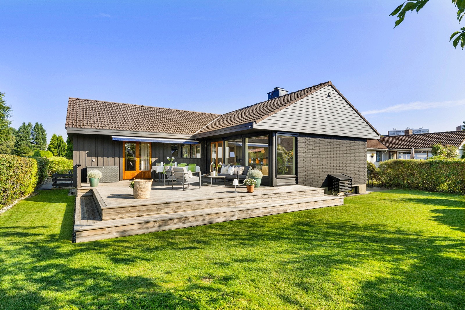 Tomten er flat og pent opparbeidet med skiferbelagt gårdsplass foran huset, samt en koselig, lettstelt hage og terrasse på baksiden. Galleribilde