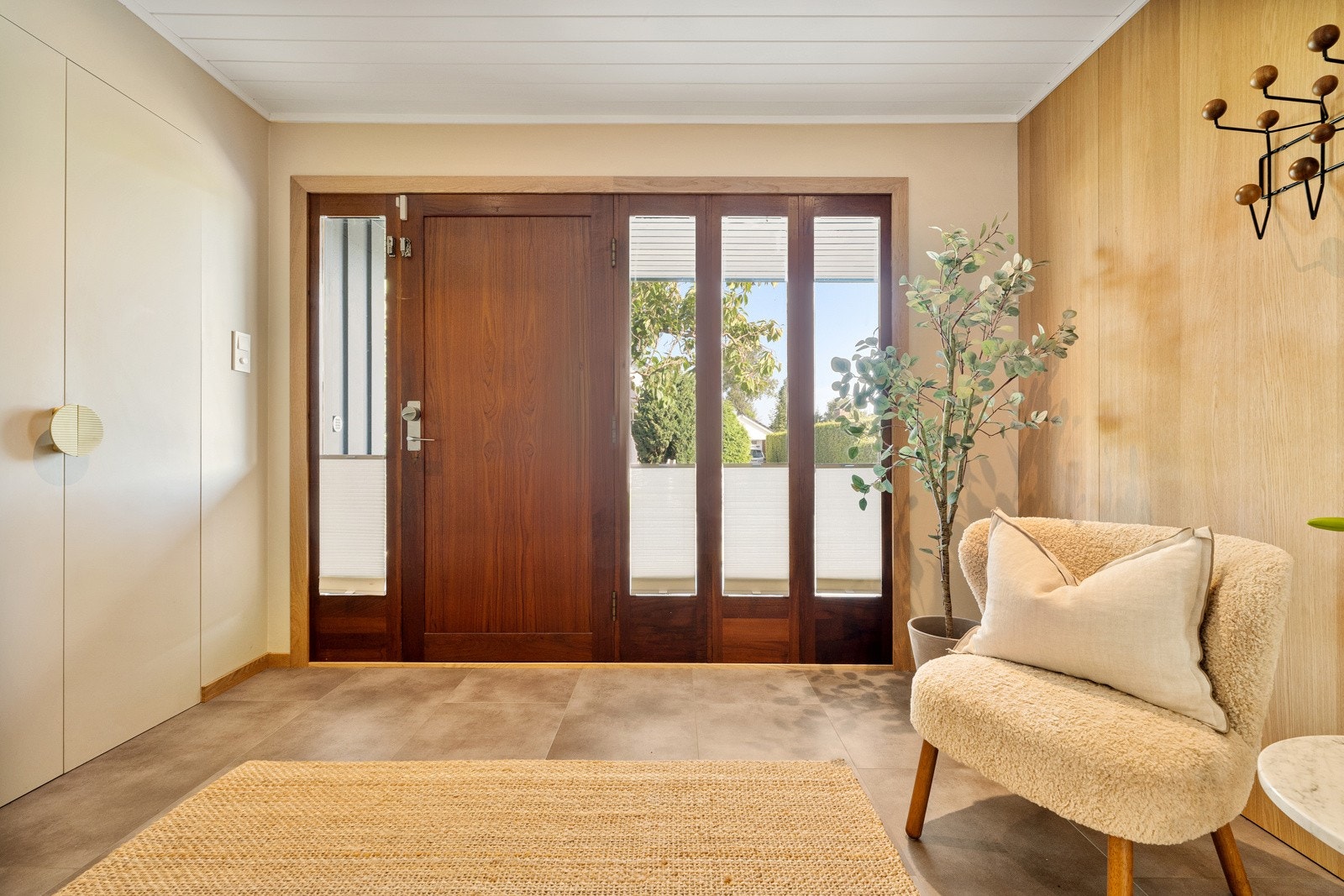 I entreen er det store, grå gulvfliser, gulvvarme og downlights i lysmalt panelhimling. Galleribilde