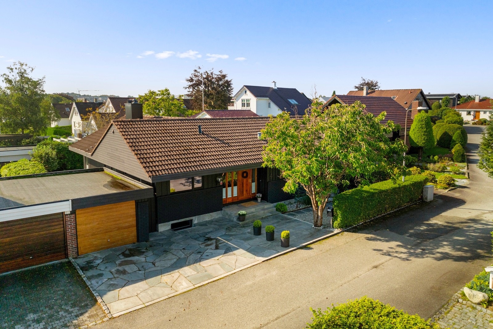 Fra garasjen kan man gå under tak rett bort til en skiferbelagt trapp som fører opp til inngangspartiet. Galleribilde