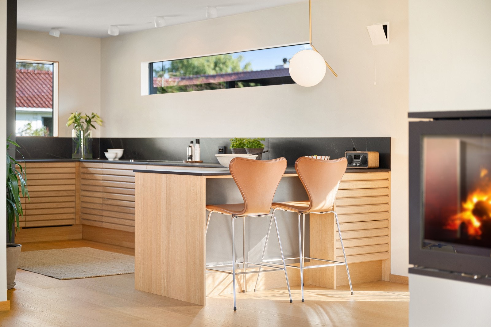 Kjøkkenet er trukket inn i en skjermet avdeling, mens resten av rommet er oppdelt i soner med fleksible møbleringsmuligheter. Galleribilde