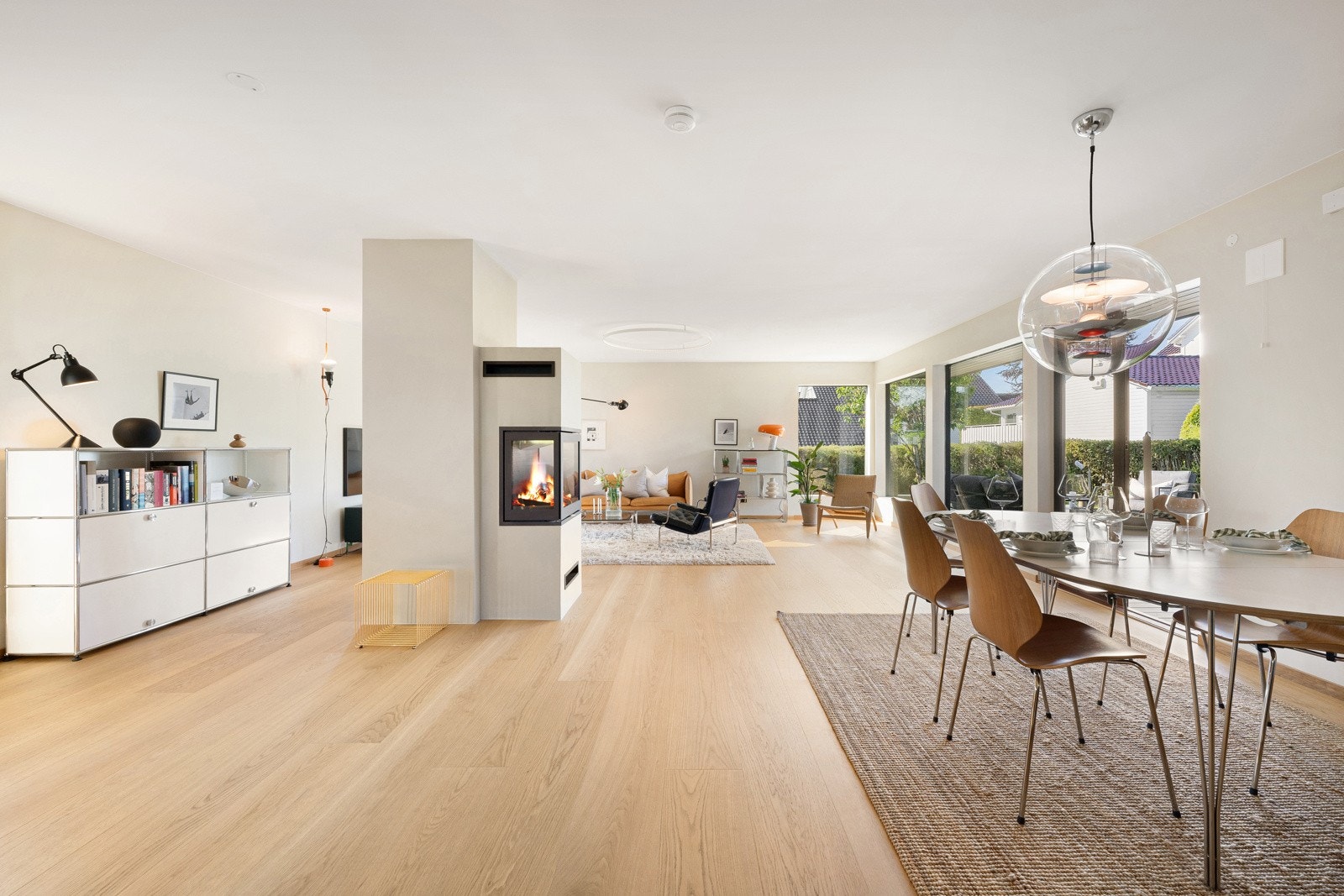 Midt i rommet er det en moderne peisovn fra Rais med glass på tre sider, og via en tofløyet dør kan man gå rett ut på den solrike terrassen. Galleribilde