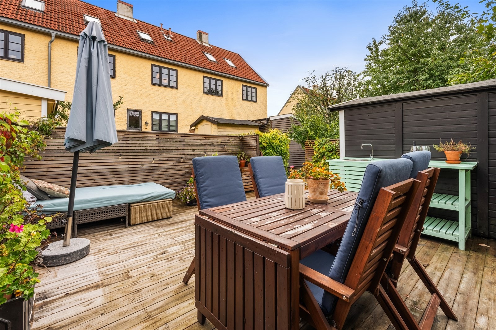 Terrassenen er utstyrt med utebod, kran m.m. God plass til spisebord, loungemøbler, beplantning og folk Galleribilde