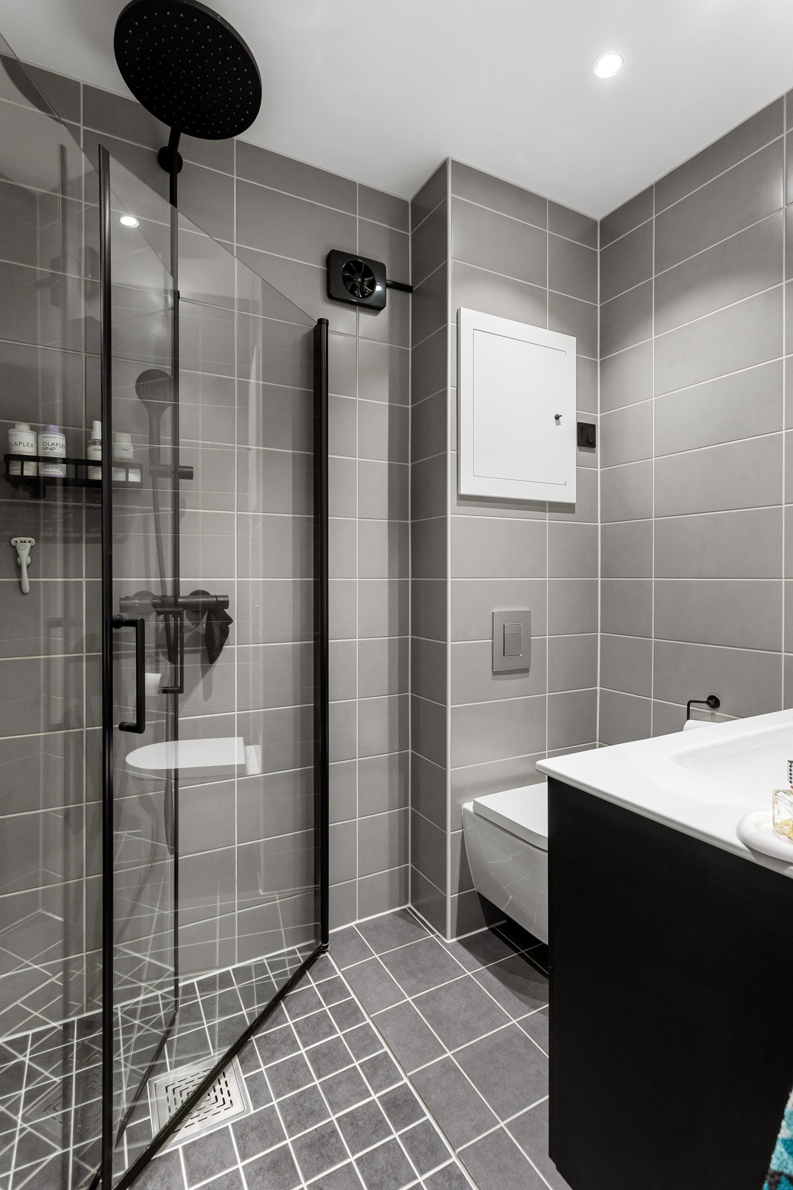 derommet har tidløse fliser på gulv og vegger, deilig gulvvarme, downlights i himlingen og mekanisk avtrekk. Gjennomgående sorte detaljer gir et tidsriktig og moderne uttrykk. Galleribilde