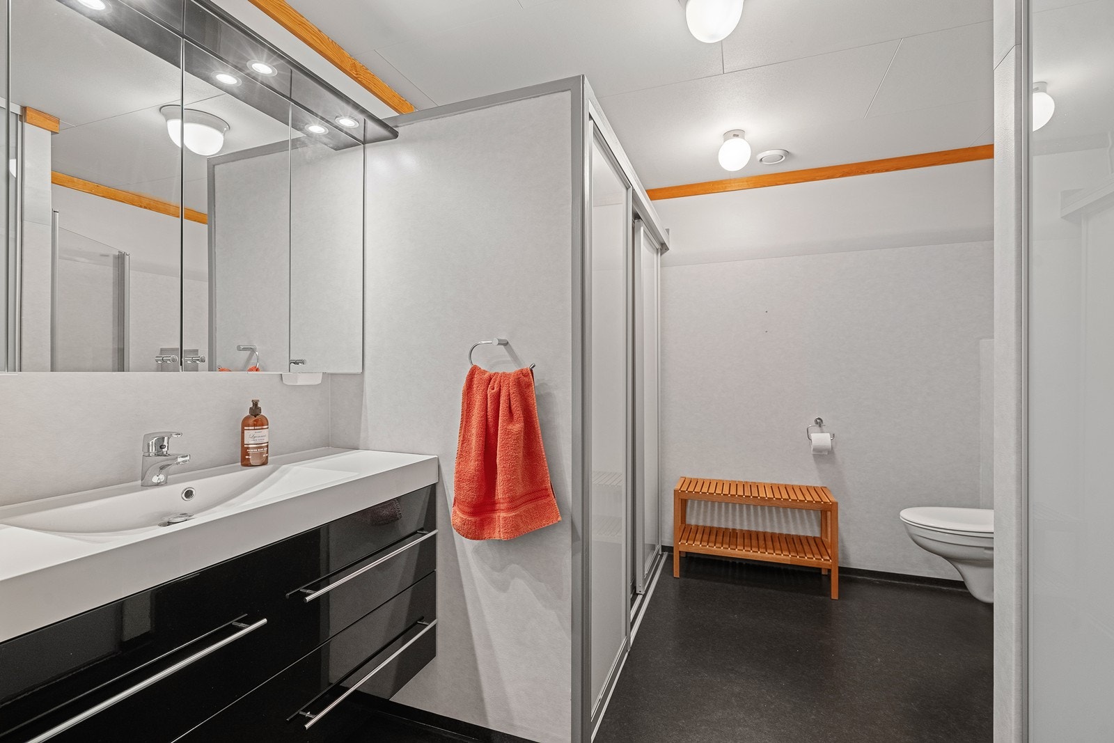 Pent bad med dusj, vegghengt toalett og god baderomsinnredning Galleribilde