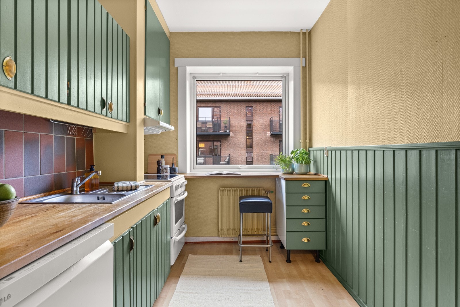 utstyrt med integrert oppvaskmaskin, frittstående kjøleskap med frysedel og komfyr med platetopp, komfyrvakt over platetopp, ventilator i overskap tilkoblet mekanisk avtrekk og nedfelt oppvaskkum med ett-greps armatur. Galleribilde