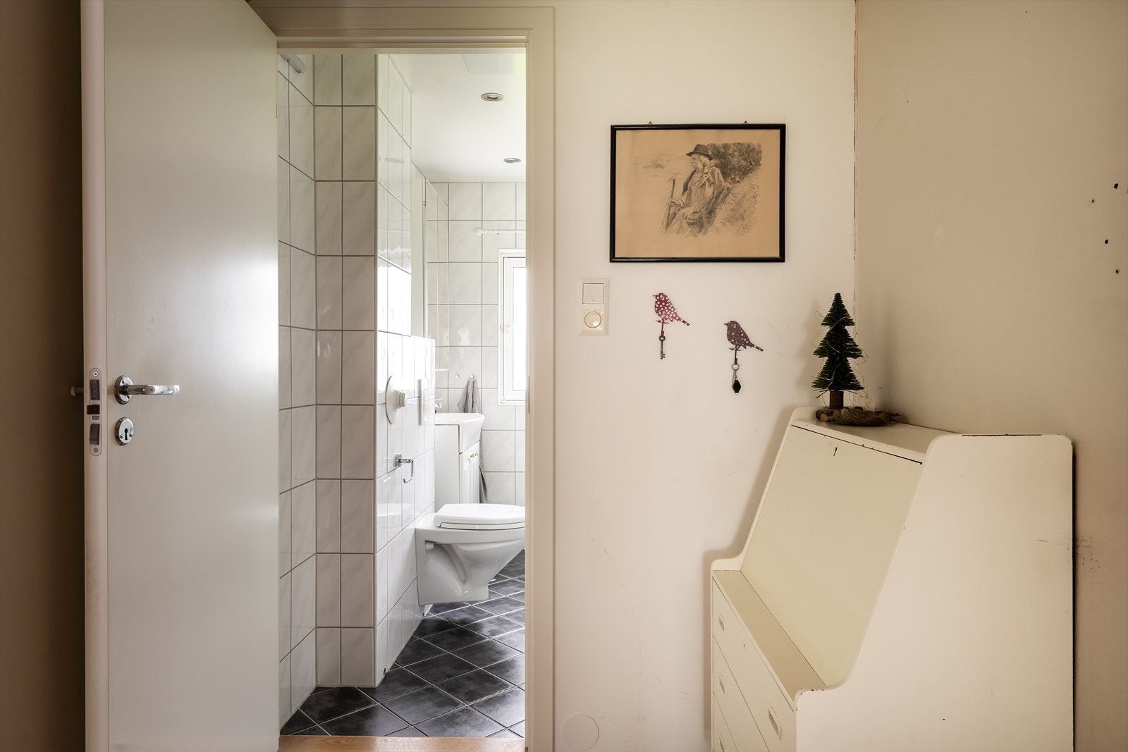 Badet er flislagt med lyse fliser på veggene og mørkere fliser på gulv, som gir elegant kontrast. Galleribilde