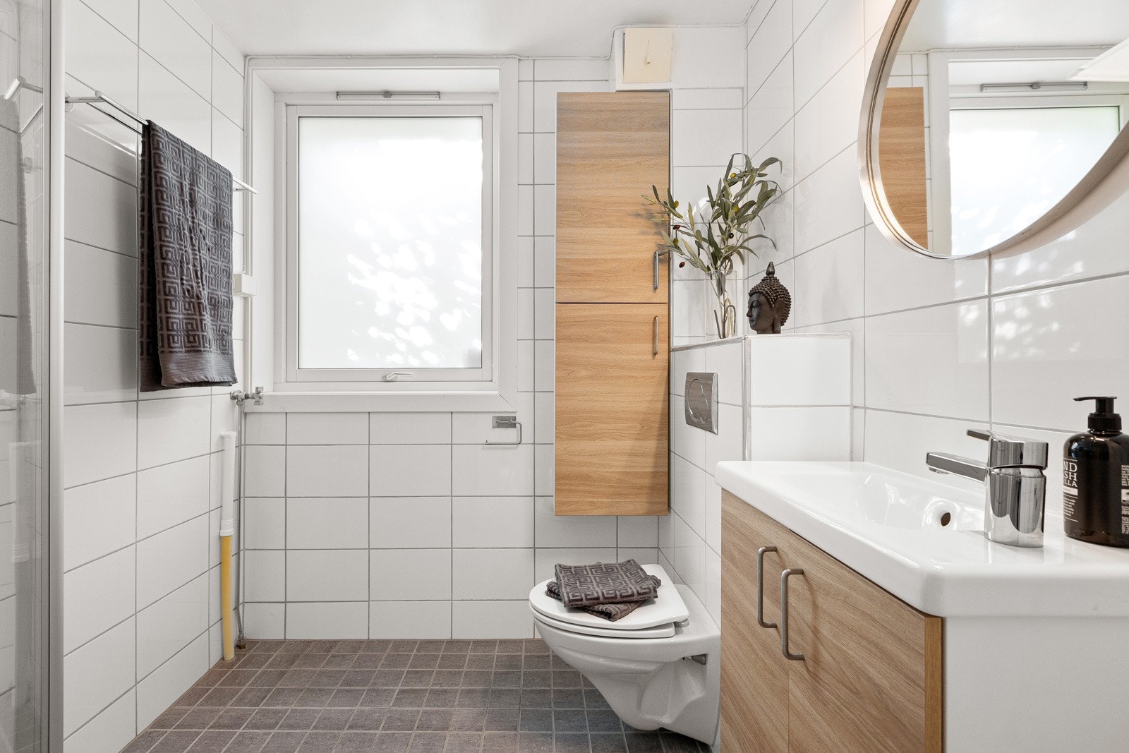 Badet har vegg- og gulvfliser som gir et elegant og moderne utseende, og oppgradert med nytt gulv og varmekabler fra 2017 og ny baderomsinnredning i 2024. Galleribilde