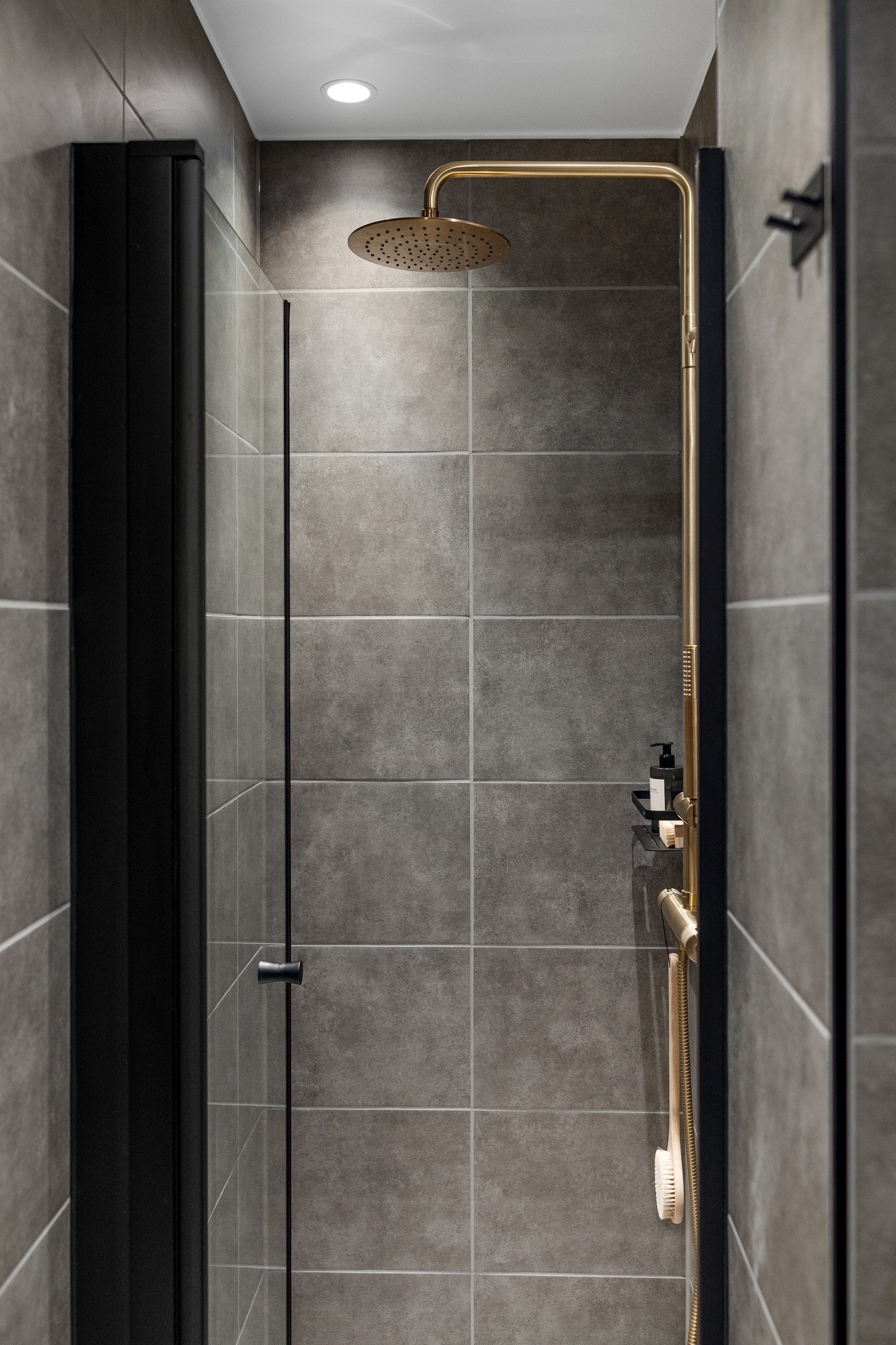 Badet har dusjhjørne tilkoblet regndusj og hånddusj, vegghengt toalett og opplegg for vaskemaskin. Galleribilde