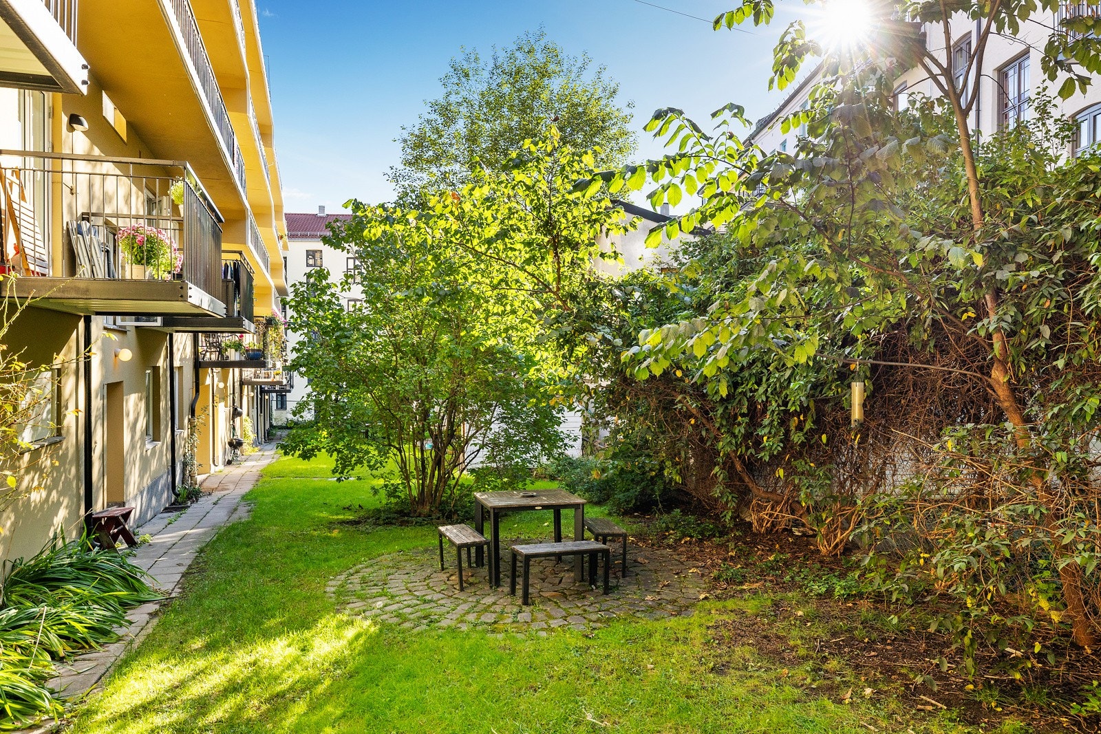 Felles opparbeidet bakgård for sameiet opparbeidet med blant annet gressplen, busker, trær, diverse beplantning og sittegruppe. Galleribilde
