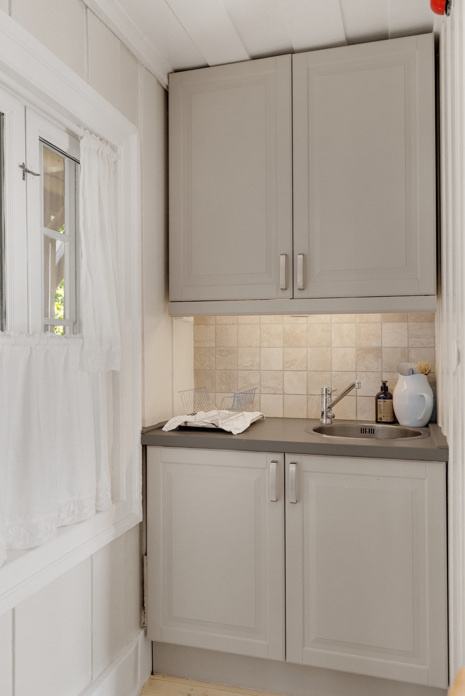 Kjøkkeninnredning med profilerte fronter, heltre benkeplate og integrerte hvitevarer. Galleribilde