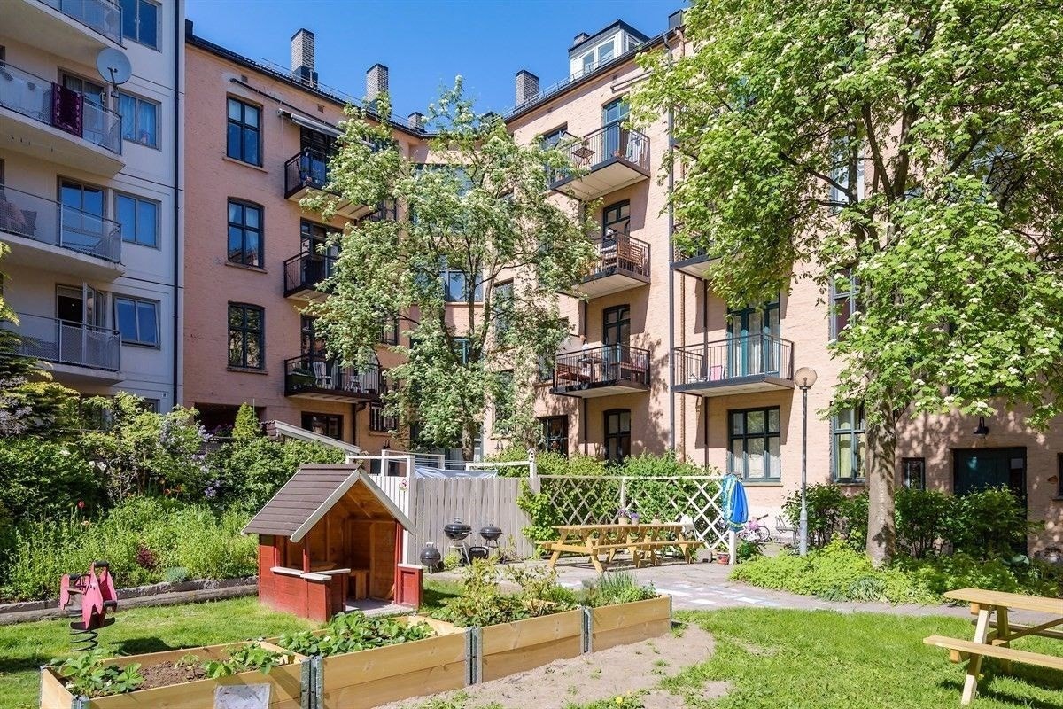 Pent opparbeidet med gressplen, beplantning, sittegrupper og lekeapparater. Galleribilde