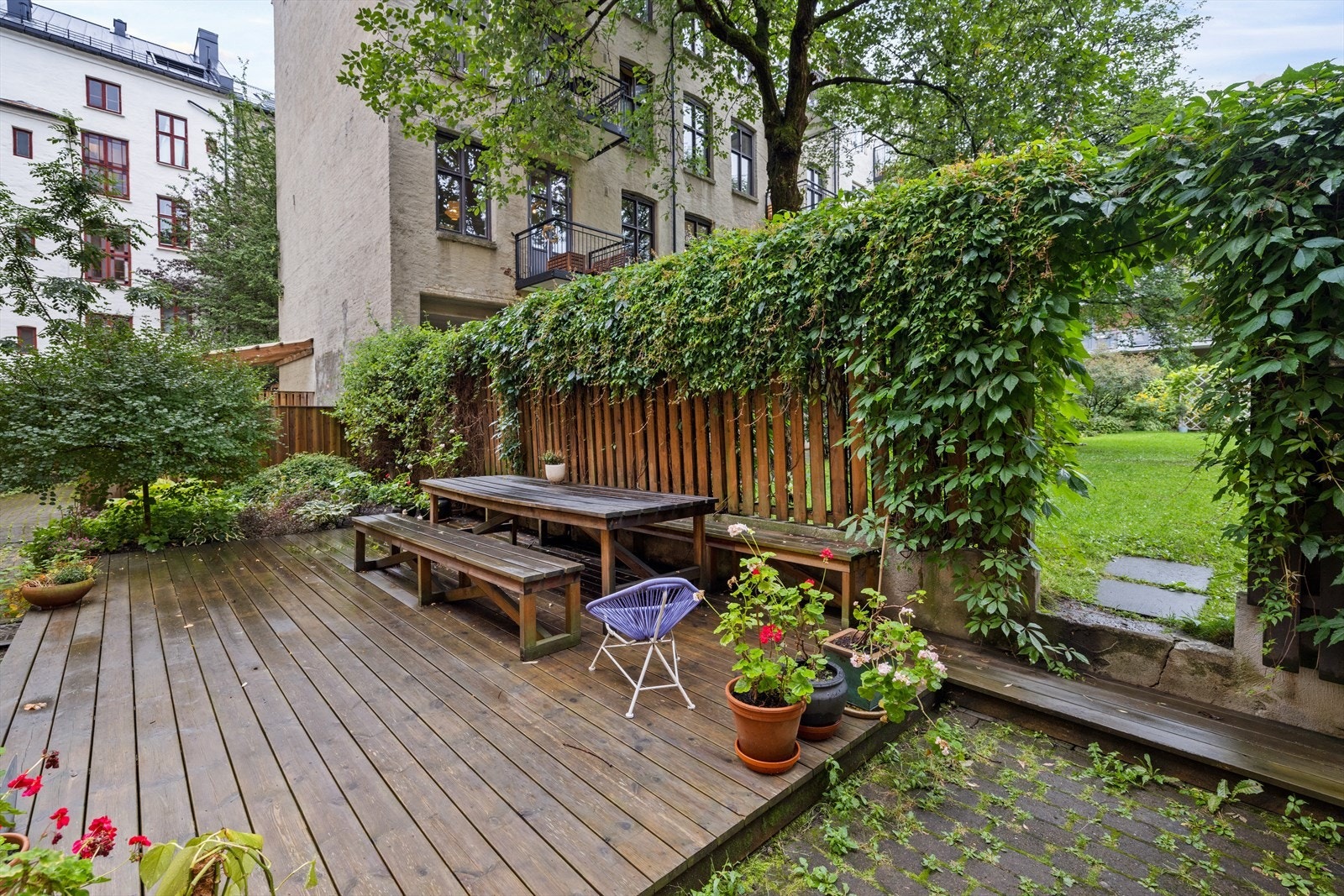 Flott og opparbeidet felles gårdsrom med flere sittegrupper for beboerne, hyggelig beplantning og gode solforhold. Galleribilde