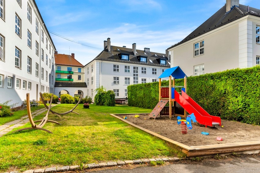Idylliske forhager og et pent opparbeidet indre gårdsrom med to grillplasser, lekeapparater og flere sittegrupper/benker. Galleribilde