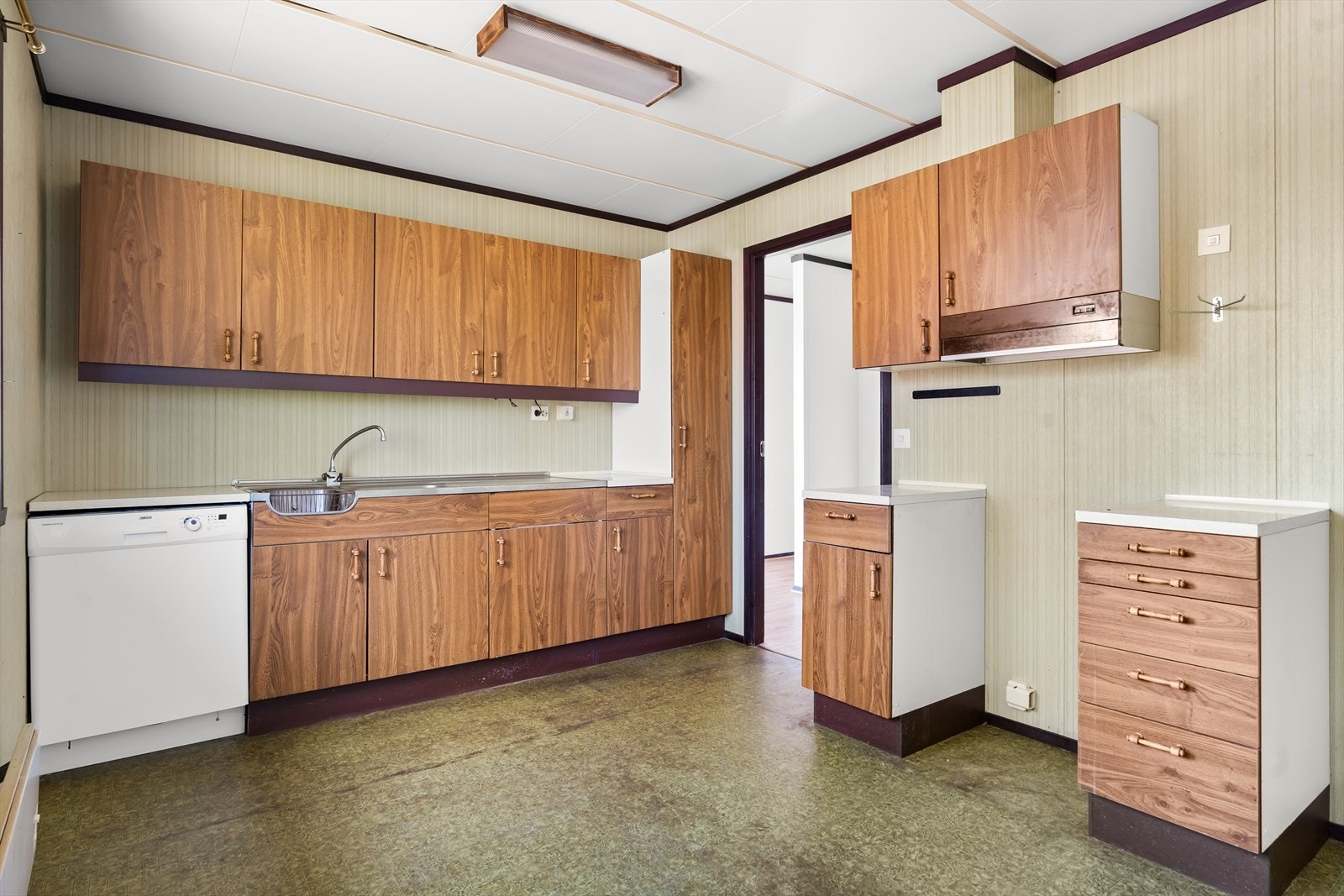 Kjøkkenet er også fra byggeår, og har folierte skrog med slette fronter og laminat benkeplate Galleribilde