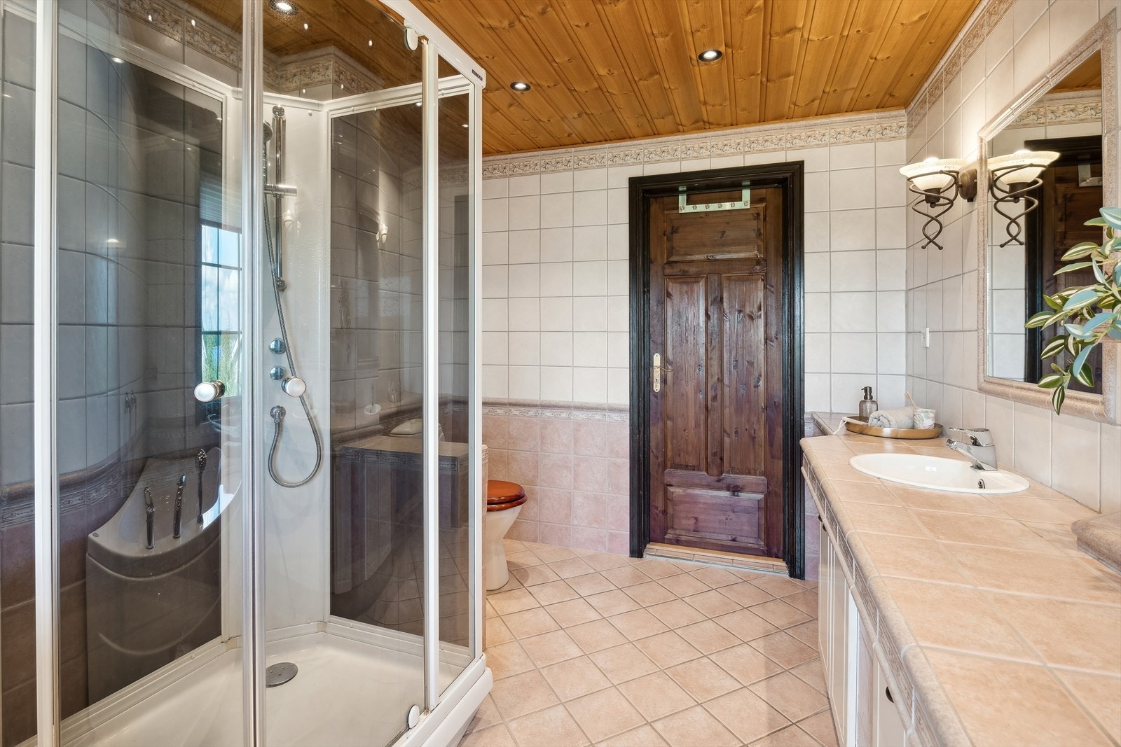 Badet er ellers innredet med et integrert servantskap som er flislagt og har to servanter, to speil, toalett og dusjkabinett. Galleribilde