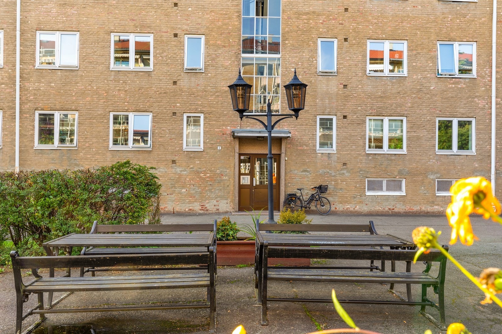 Koselig fellesområde foran bygården med sitteplasser. Galleribilde