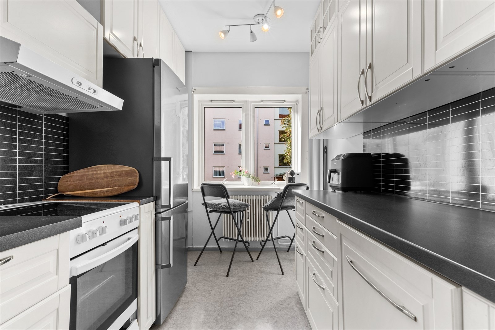 Velutstyrt kjøkken med moderne hvitevarer og spiseplass. Galleribilde