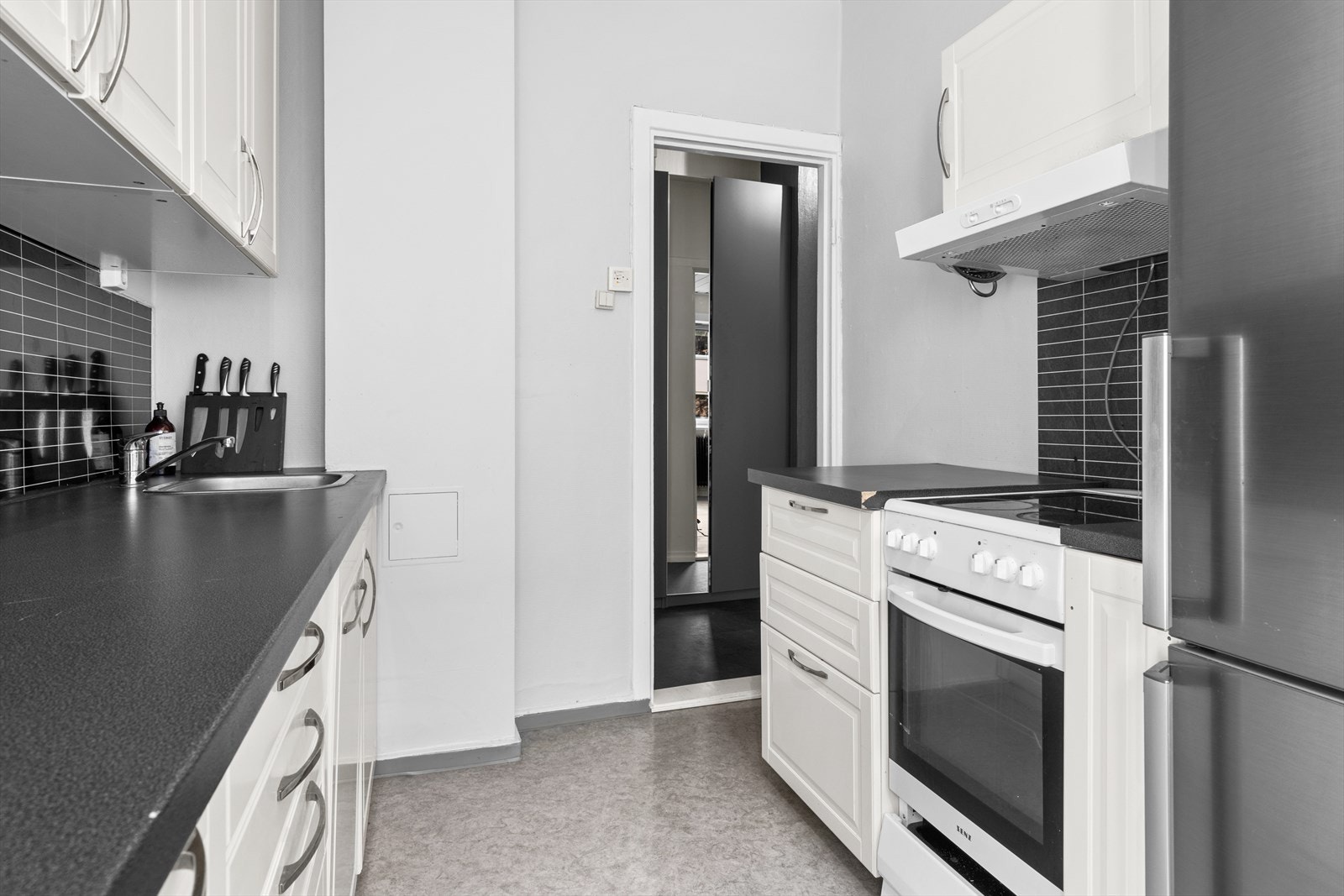 Elegant kjøkken med stilrene overflater og funksjonelle detaljer. Galleribilde