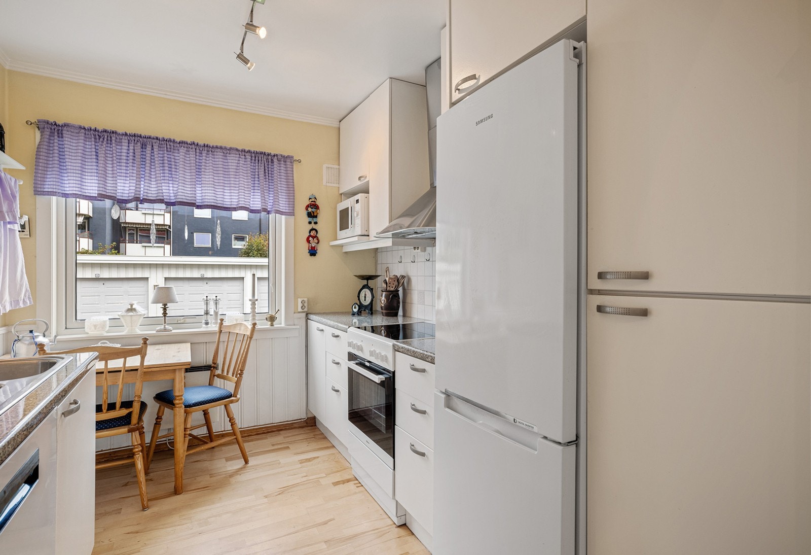 Kjøkkenet har god benkeplass og fin kombinasjon av skuffer og skap for oppbevaring. Det er plass til et spisebord foran vinduet. Galleribilde