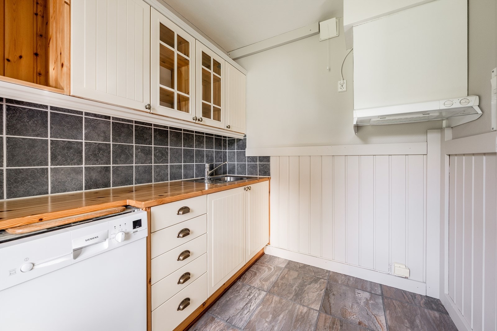 Kjøkken har belegg på gulv, malte brystpanel på vegger og malt tak. Oppvaskmaskin medfølger salget. Galleribilde