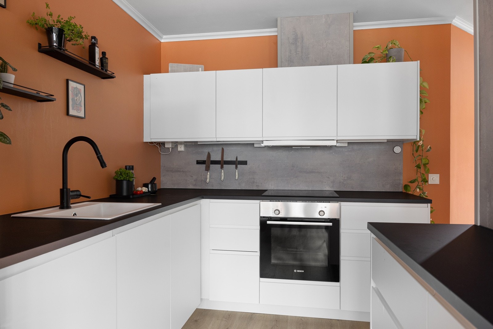 Hvite fronter og veggplate over laminat benkeplate. Galleribilde