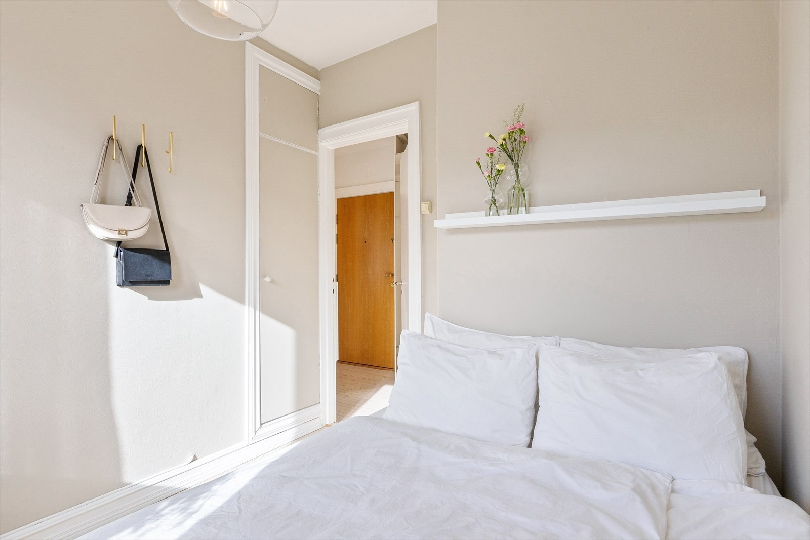 På soverommet finner du et smart innebygd skap i veggen, som vender inn mot kjøkkenet. Det gir praktisk oppbevaringsplass samtidig som det bevarer rommets rene linjer. Galleribilde