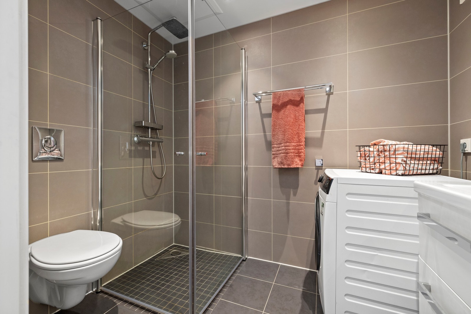 Baderommet er fra 2018 med innredning bestående av dusj med innfellbare dører i herdet glass, servant, vegghengt toalett med innebygget sisterne og opplegg for vaskemaskin. Det er benkeskap og veggskap med speil- og glatte fronter med god plass for lagrin Galleribilde